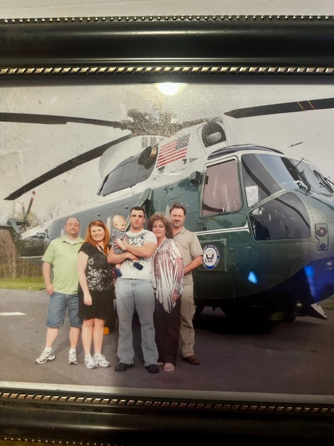 Family group standing together in front of Marine One, the green and white presidential helicopter, at Camp David Family Day